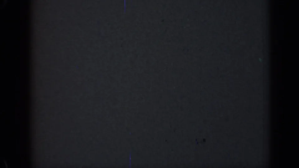 Dark 1947 Illinois 8mm frame with a broad black vertical band, faint surface scratches, dust specks, and uneven film density.