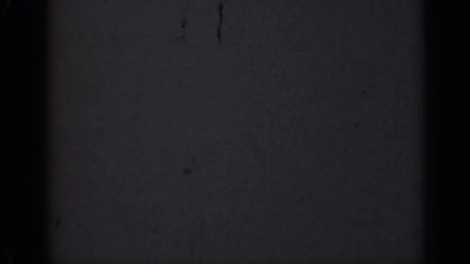 Dark 1947 Illinois 8mm home-movie frame showing blank film texture, black vertical edge bars, scattered dust, scratches, and uneven exposure.