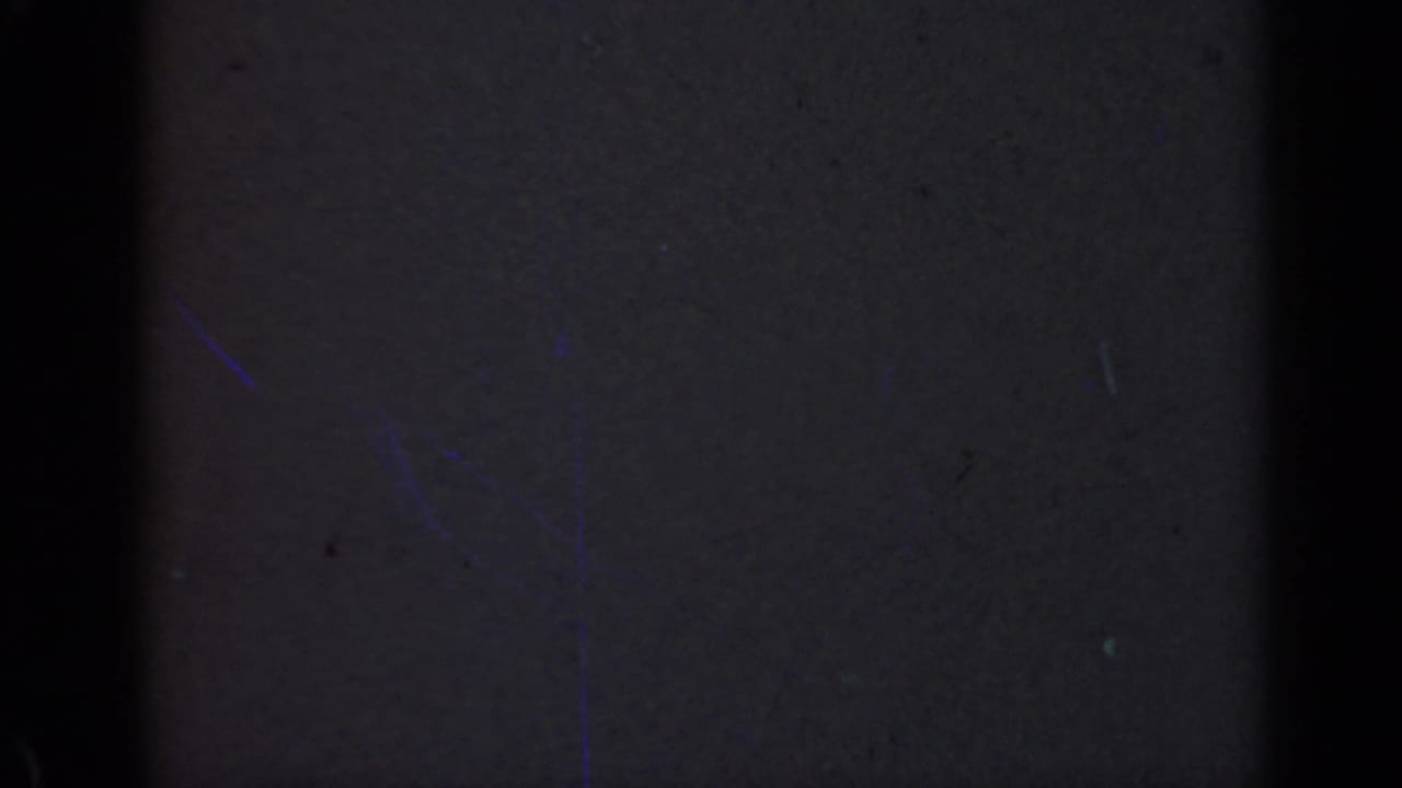 1947 Illinois 8mm frame that appears almost entirely dark, with a central black band, edge shadowing, and faint film speckles.