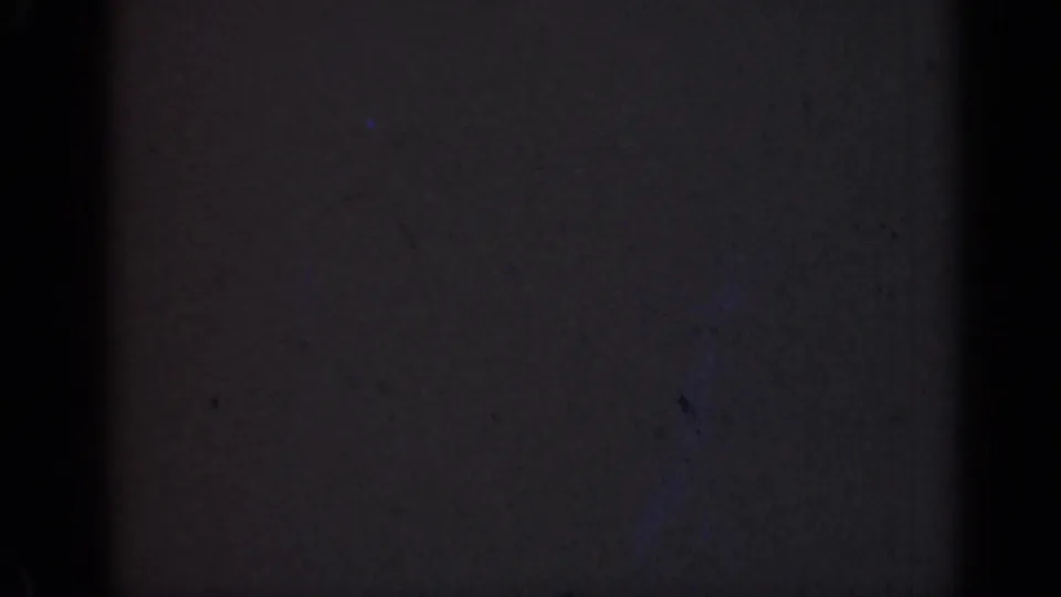 Dark 8mm frame from the 1947 Illinois clip, showing faint grain, small dust flecks, and a heavy vertical black band.