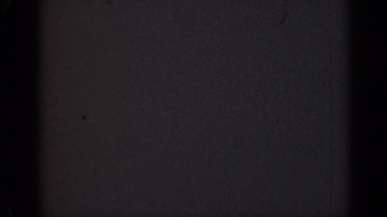 Nearly black 8mm frame with faint gray exposure and vertical edge shadows.