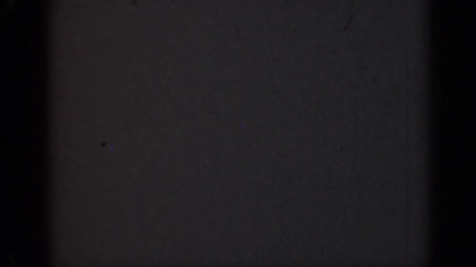 Damaged 1947 Illinois 8mm home-movie frame with mostly dark exposure, faint gray field, grain, and edge shadows.
