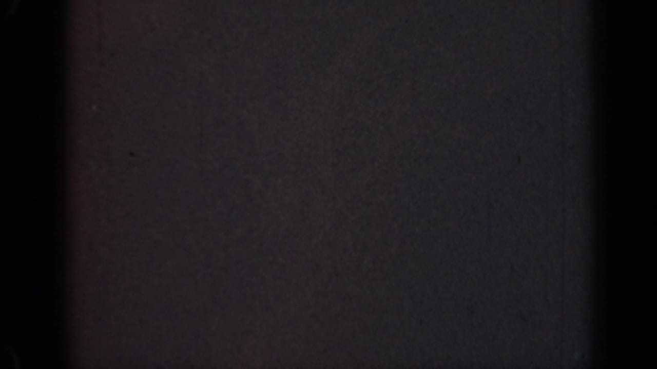 1947 Illinois 8mm home-movie frame showing near-total darkness with faint film grain and dark vertical banding.