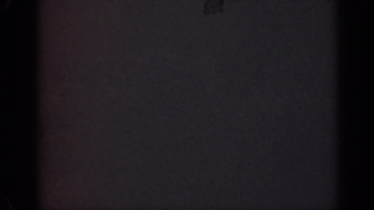 1947 Illinois 8mm home-movie frame with deep underexposure, faint color noise, and a dark vertical strip.