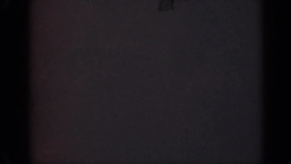 1947 Illinois 8mm home-movie frame with deep underexposure, faint color noise, and a dark vertical strip.