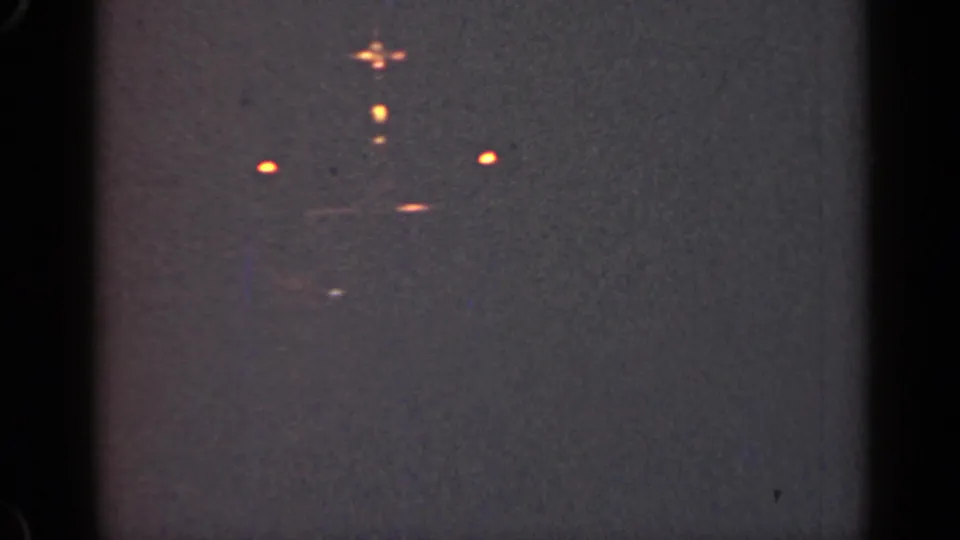 1947 Illinois 8mm frame showing distant orange vessel lights in a dark, grainy night scene.