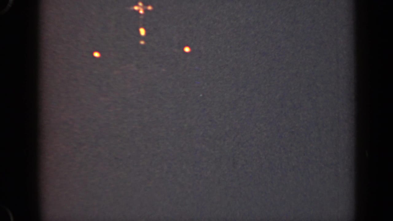 1947 Illinois 8mm night frame with scattered orange lights from a distant vessel or waterfront source.