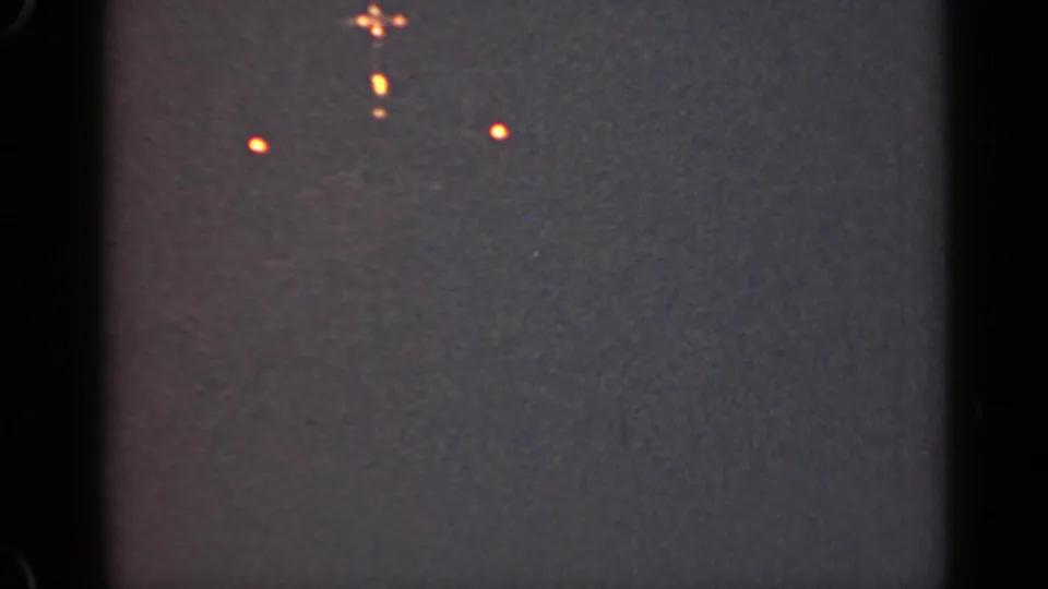 1947 Illinois 8mm night frame with scattered orange lights from a distant vessel or waterfront source.