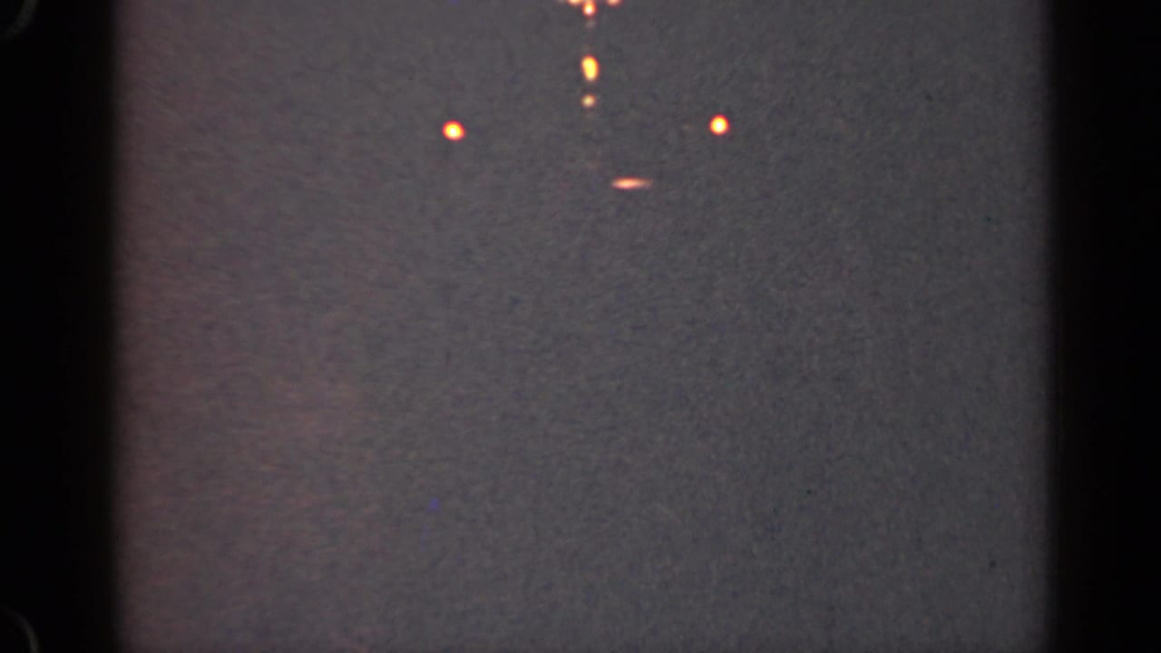 Dim gray surface with several small orange lights near the top of the frame.