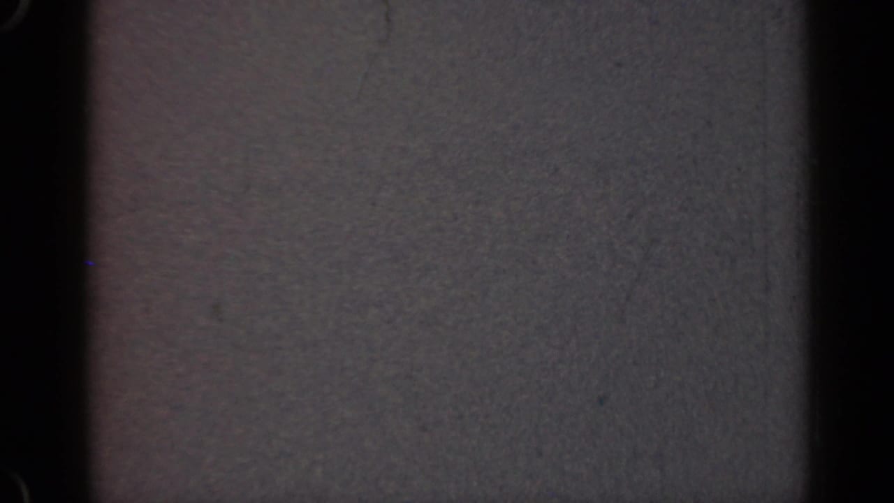 Gray fuzzy screen texture with dark vertical bands and visible film grain.