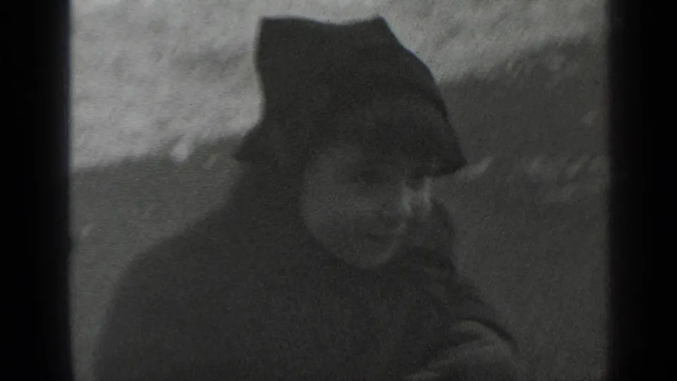 A closer 1947 New York frame shows the bundled child in a dark hat, with the seesaw and snowy ground partly visible.