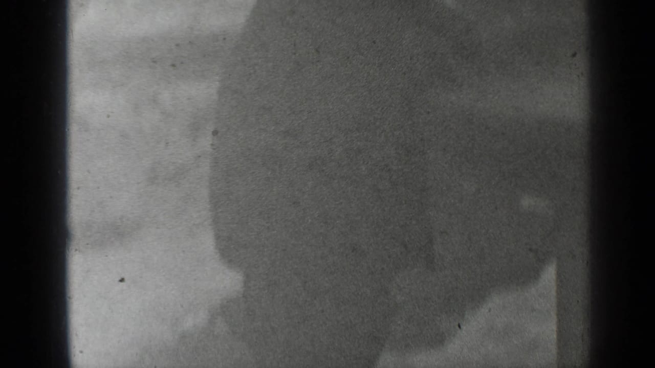 Partial view of a person in dark clothing, mostly seen as a silhouette.