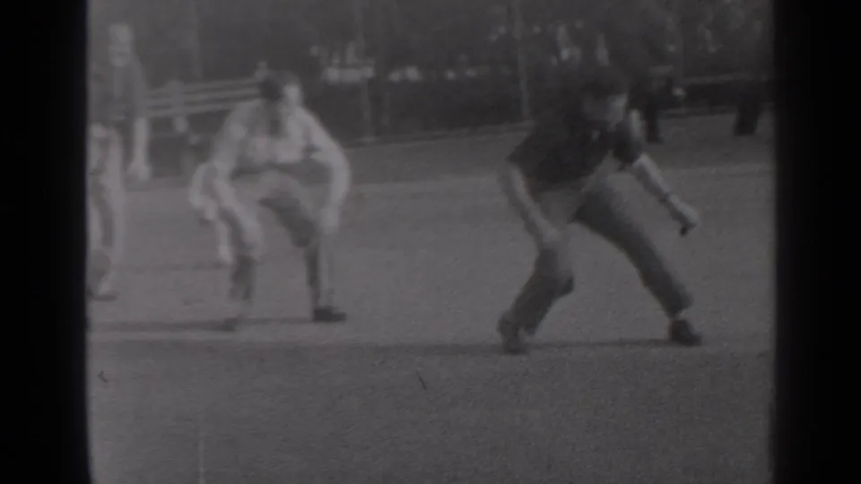 A young man lands after jumping over a crouched player during a 1947 New York park leapfrog scene.