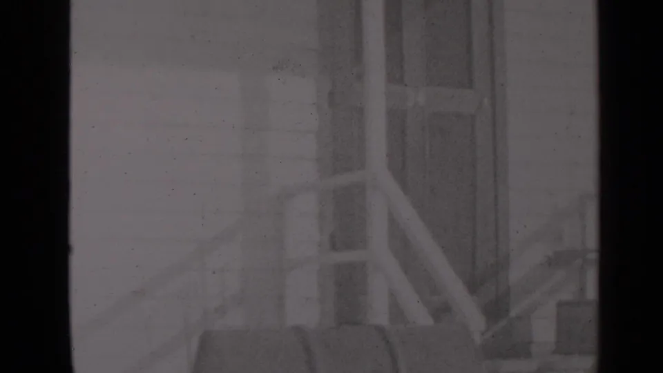 A soft black-and-white frame shows exterior porch steps, railing, and a residential door in the supplied New York winter setting.