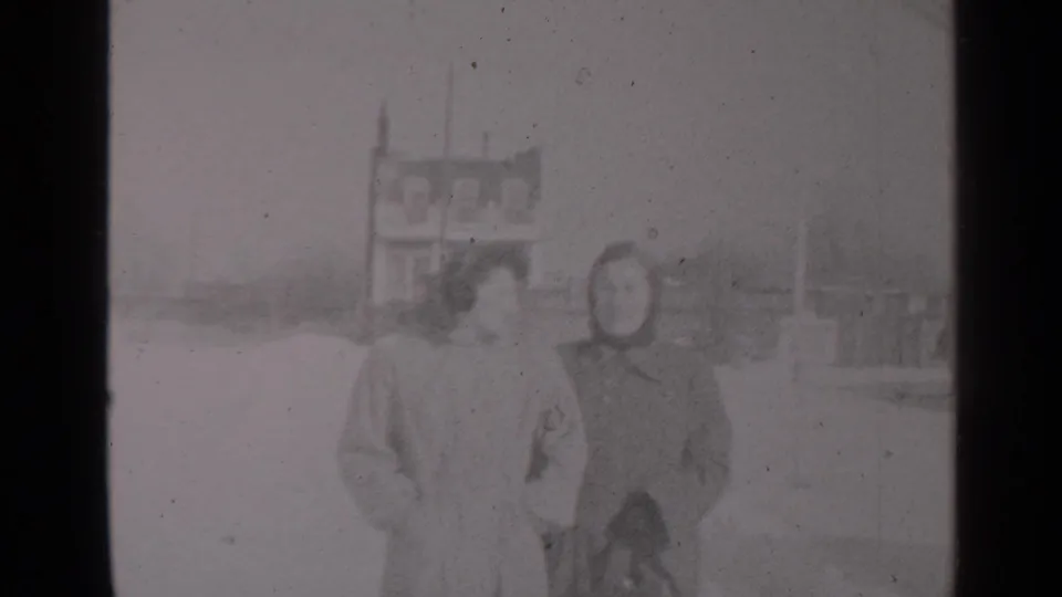 The women are framed closer in the 1947 New York winter street scene, standing or walking together in heavy coats.