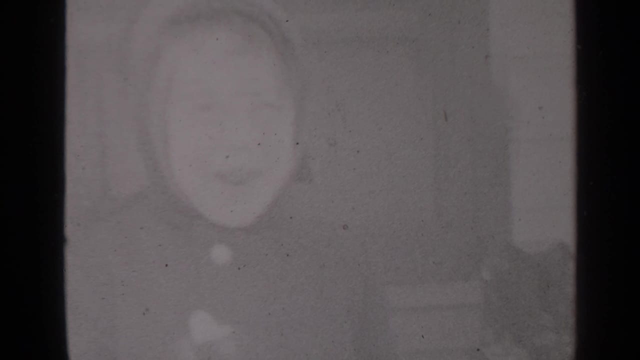 Soft, grey partial frame with a faint circular mark and film grain.