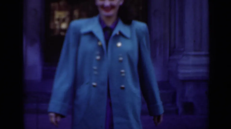 In the 1947 New York clip, an adult woman in a bright green coat appears near a dark glass doorway and stone facade.