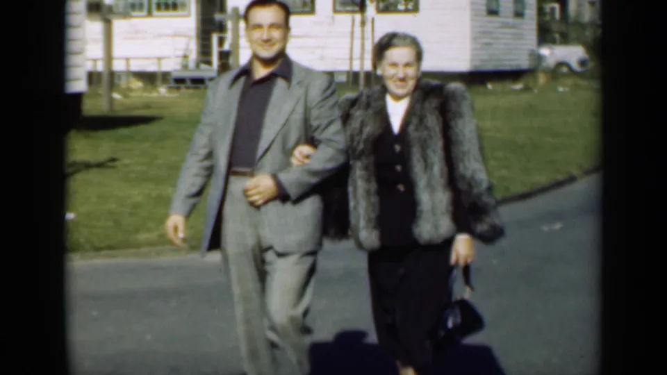 A closer 1947 New York frame shows the couple walking arm-in-arm, the man in a gray suit and the woman in a fur coat.