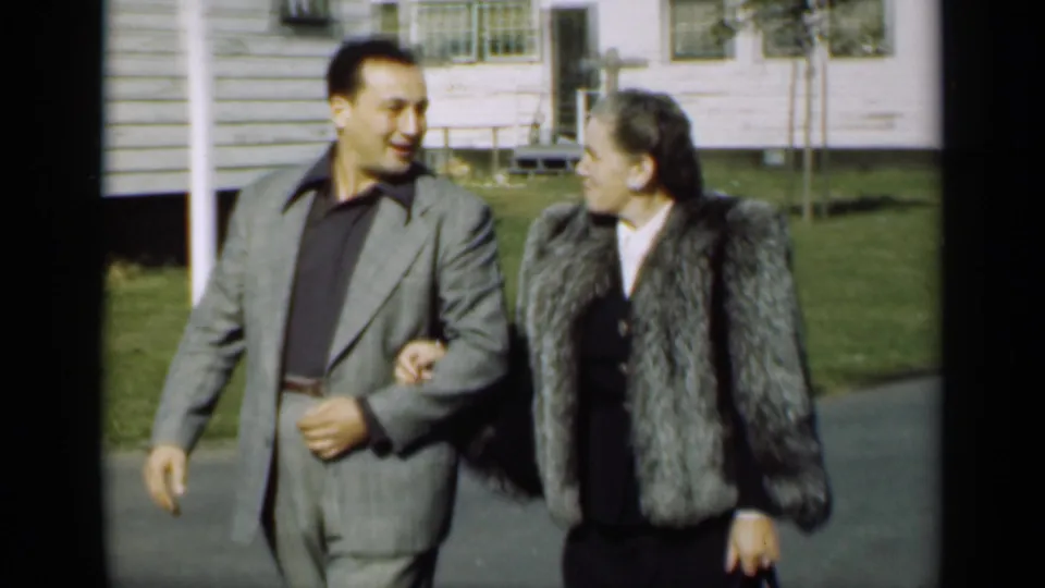 The couple looks toward each other while walking arm-in-arm in this 1947 New York home-movie frame.
