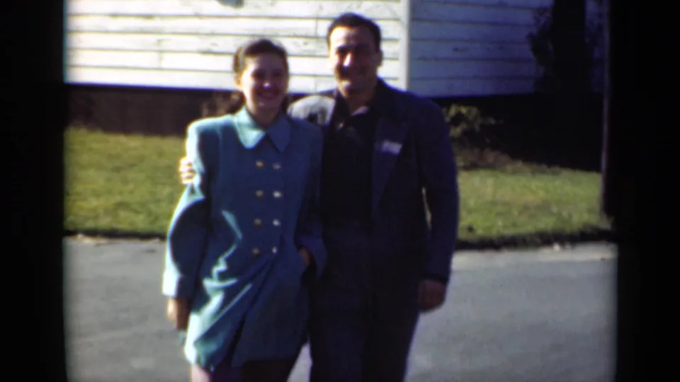 The final 1947 New York frame shows the couple close to camera, smiling in front of a white clapboard house and lawn.