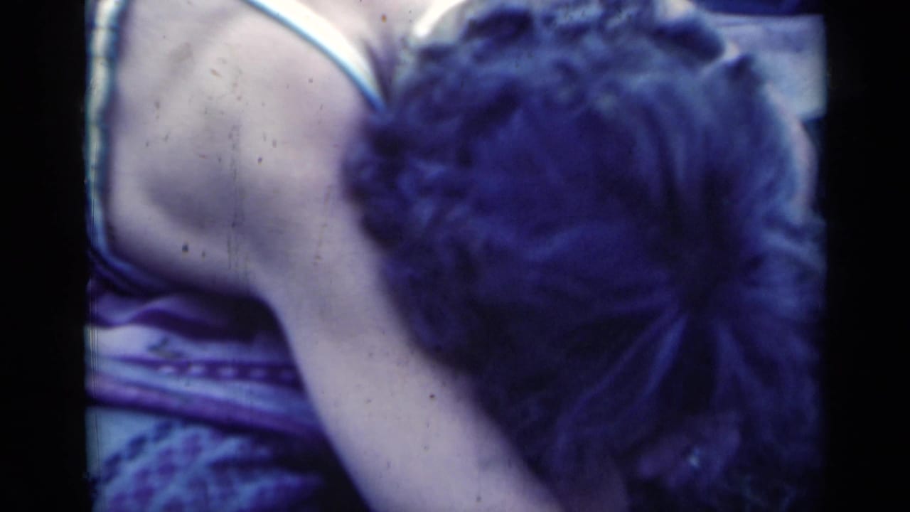 In this 1948 Indiana 8mm frame, a young woman leans forward on a blanket in close handheld framing.
