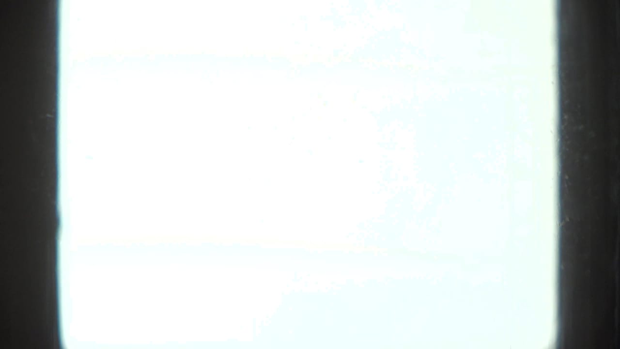 Bright overexposed area beside dark film border and a partial tabletop scene.