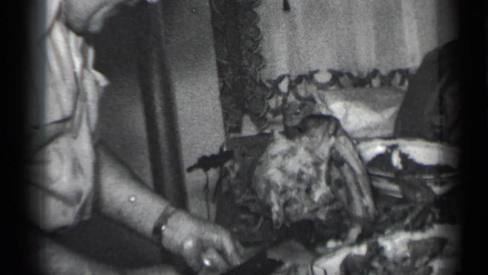 The final frame centers on the tabletop action, with the man's hands, knife, meat, dishware, and patterned curtains visible.