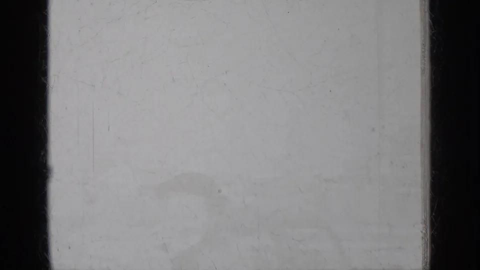 Faint, nearly washed-out 8mm view with scratches and barely visible exterior forms in the New York travel footage.