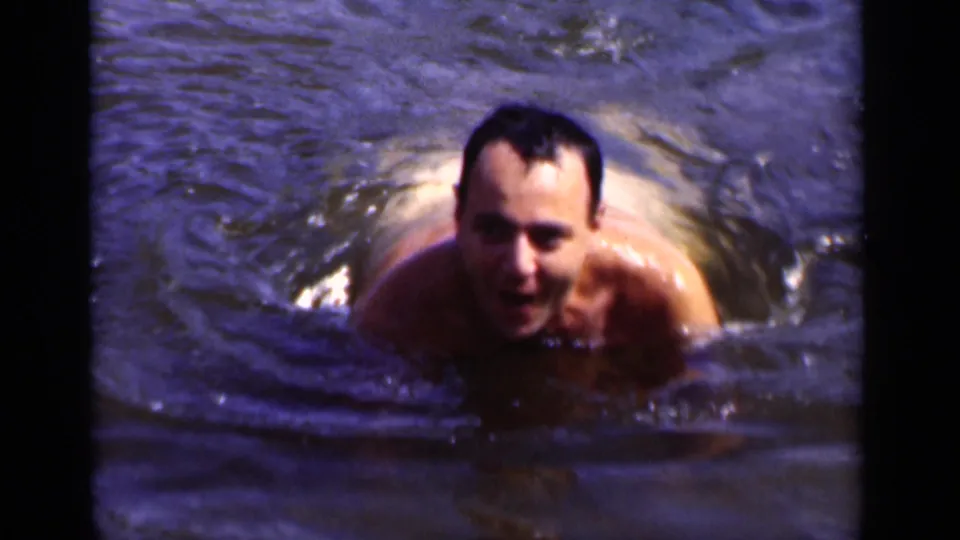 The swimmer comes closer to the camera, with his face, shoulders, and water wake visible in the 1951 New York footage.