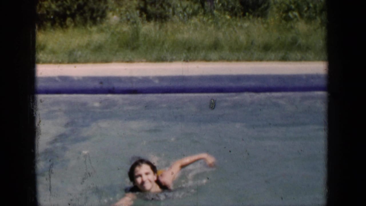 Child swimming in a pool near the left side of the frame.