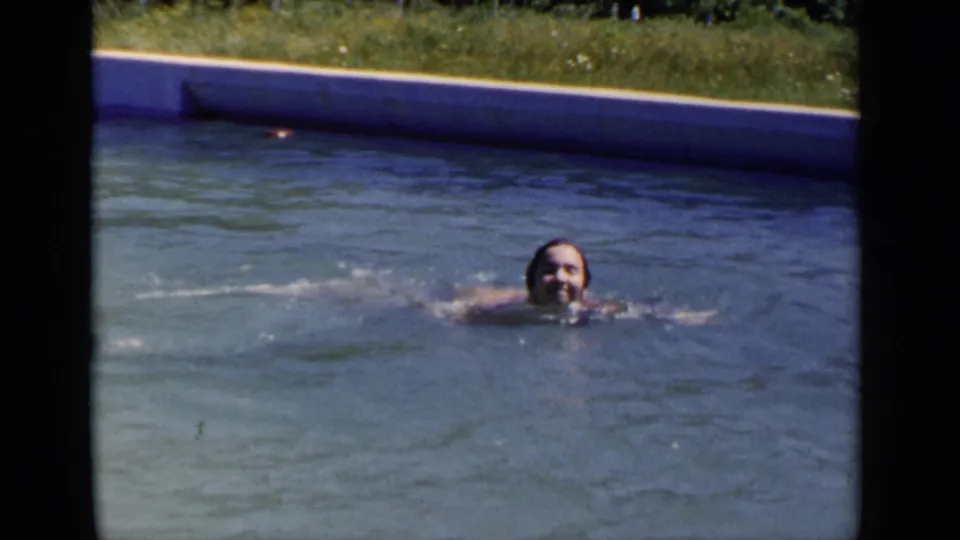 1951 New York 8mm home-movie frame of a swimmer facing the camera in a backyard-style outdoor pool.