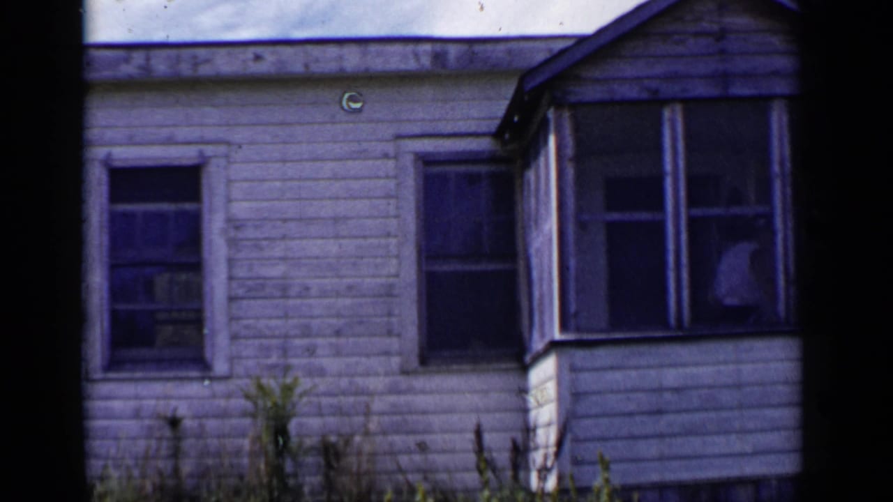 White clapboard house with screened porch and curtained windows.