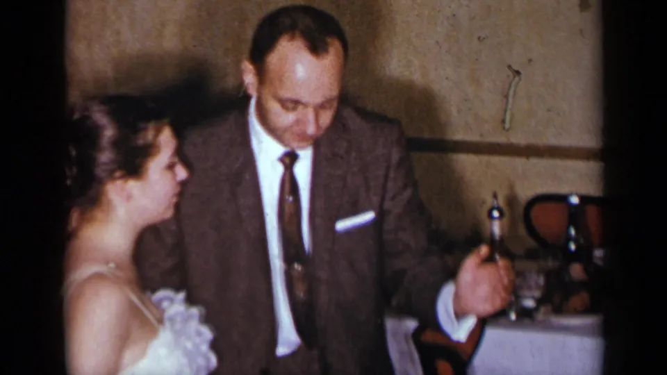 At the end of the clip, the suited man and woman remain close together on the dance floor beside a table in the 1954 New York interior.