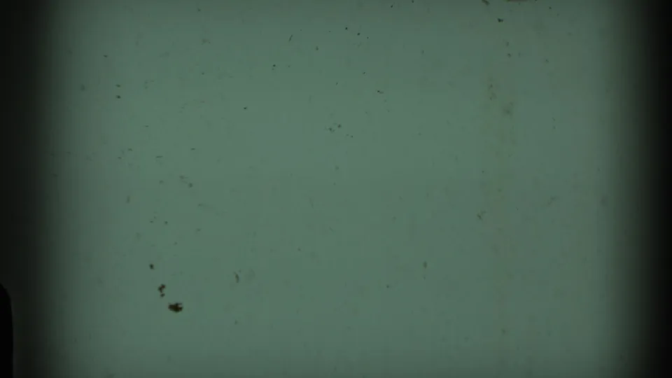 End of the 8mm clip shows a blank greenish frame with film grain, dust marks, and darkened edges.