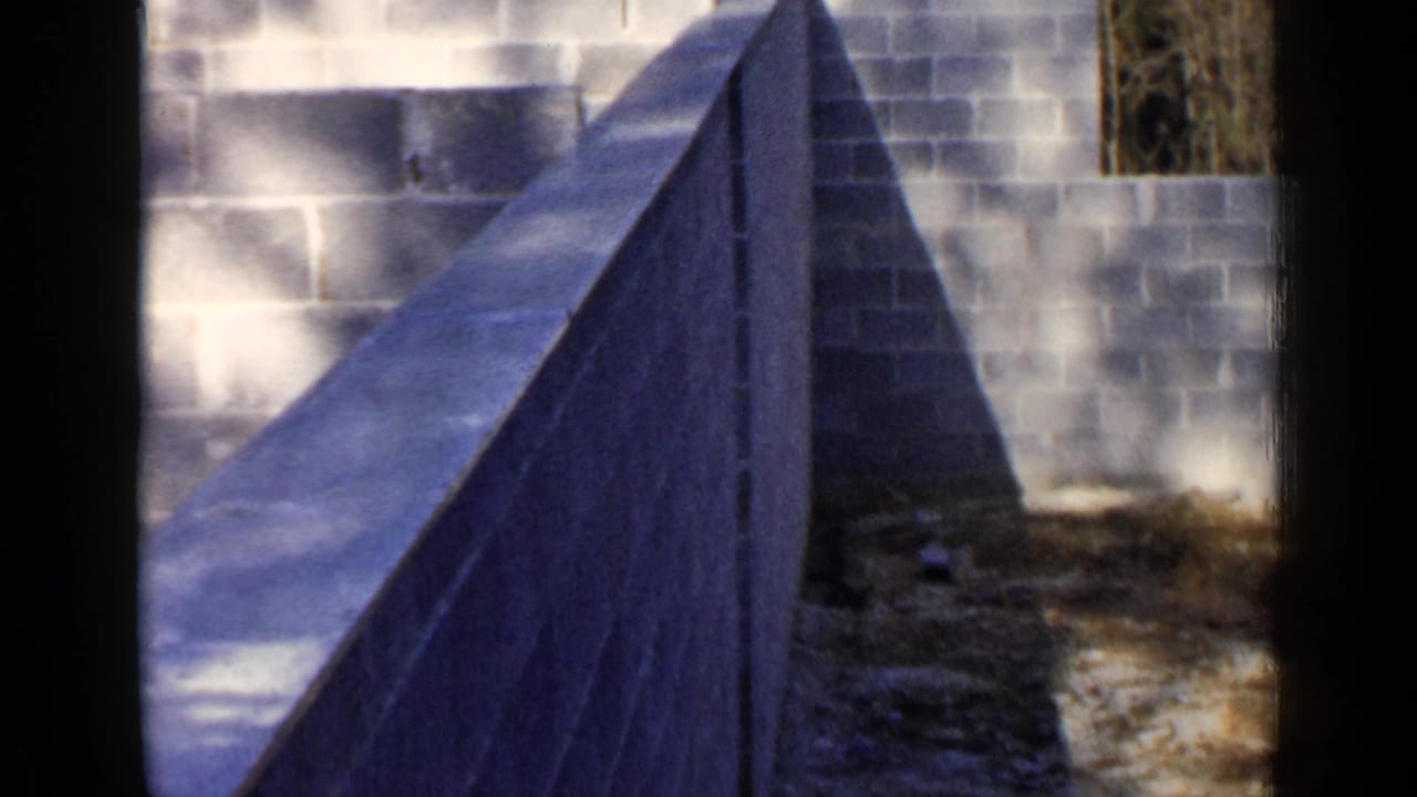 Cinder block wall and narrow unfinished wall beside dirt ground.