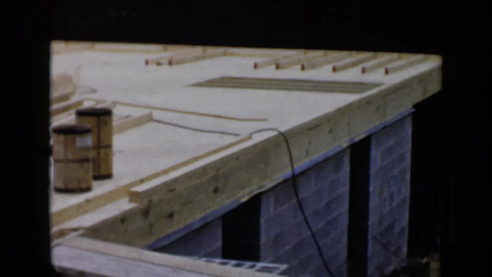 Wood framing and cinder block walls at a Birmingham, Alabama building site, filmed from above in 1957.