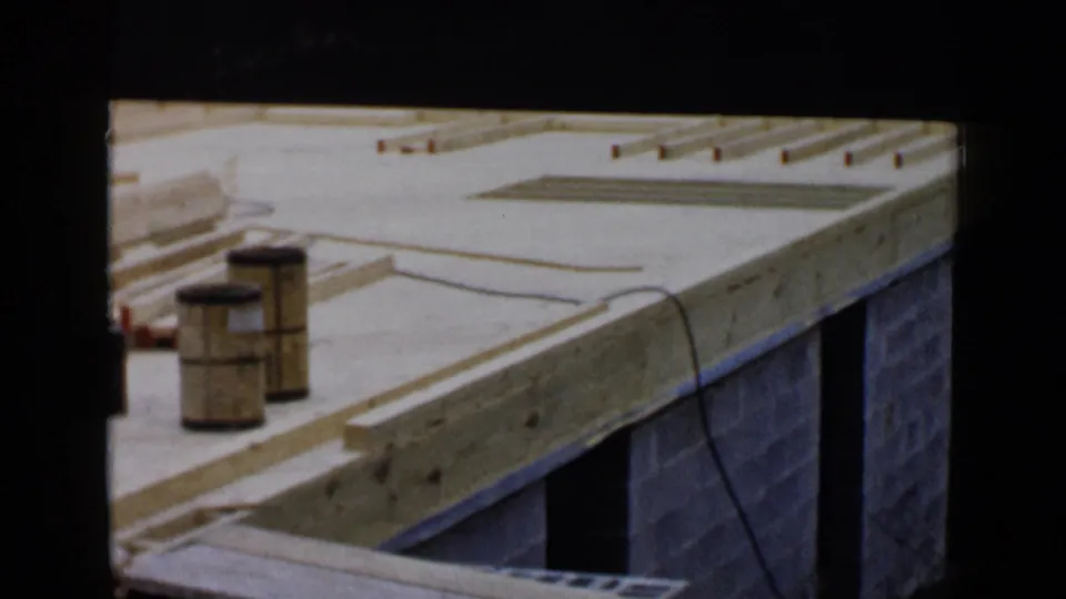 Exposed lumber and joists cross a cinder block foundation in this 1950s Birmingham home-movie frame.