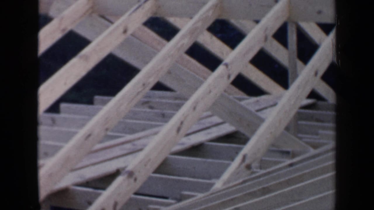 Angled roof framing with diagonal wooden supports and decking boards.