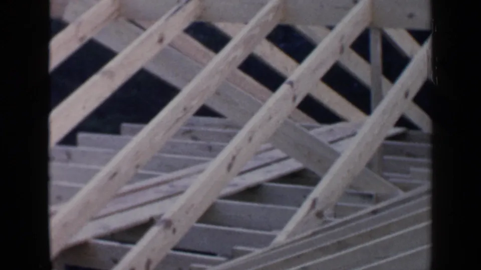 Angled 8mm view of a Birmingham house roof frame, with diagonal supports crossing over rows of decking boards.