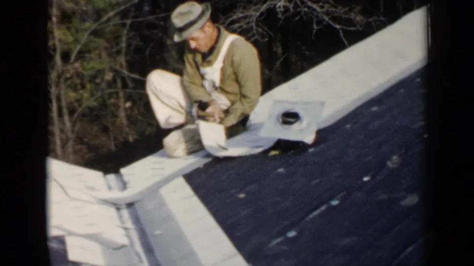 The final frame shows the man kneeling on a dark residential roof near a small vent and pale flashing in Birmingham, Alabama.