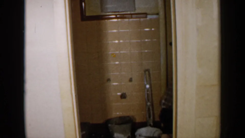 A Birmingham residential interior in 1957, looking through a doorway toward a tiled bathroom or shower space under work.