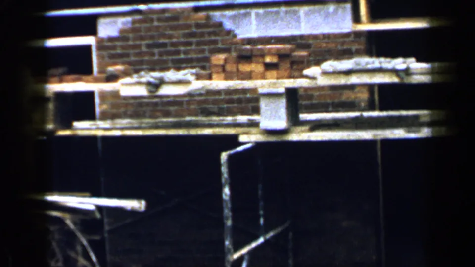 A close view of the Birmingham brick construction area shows scaffold planks, stacked bricks, buckets, and dark surfaces below.