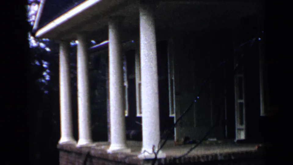 A closer 1957 view of the Birmingham house shows porch columns, an open doorway area, railing, and deep shade.