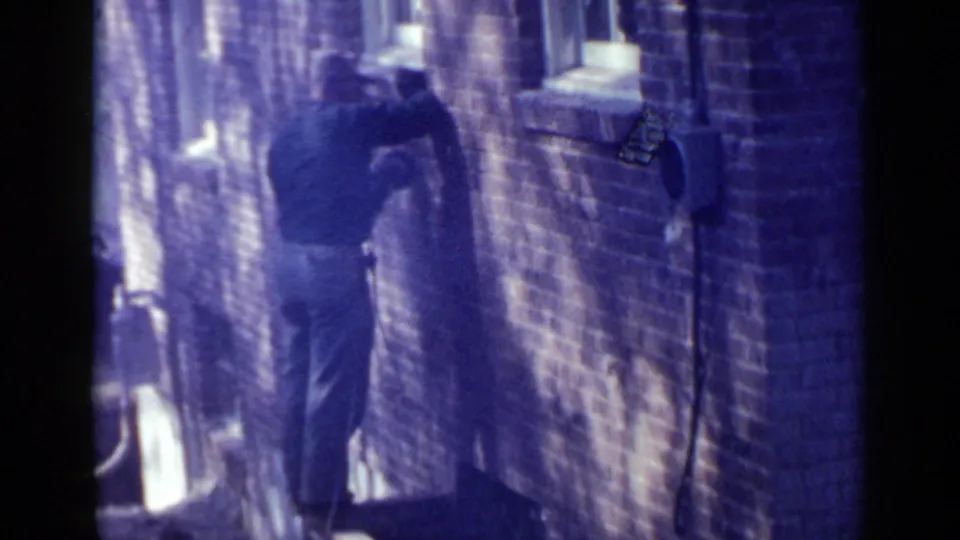 The final frame is softer and more faded, showing the man near the Birmingham brick wall and mounted utility hardware.