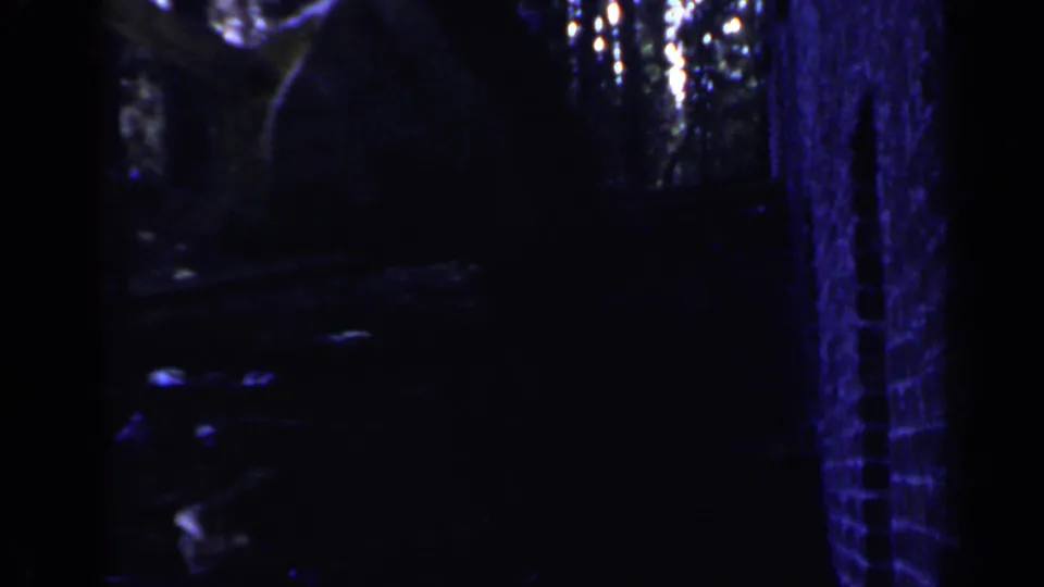 1957 Birmingham 8mm frame with a dim, blue-tinted glimpse of industrial forms and possible excavation equipment.