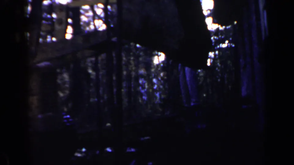 The final 1957 Birmingham frame shows a dim industrial area with vertical supports, bright background light, and shadowed machinery forms.