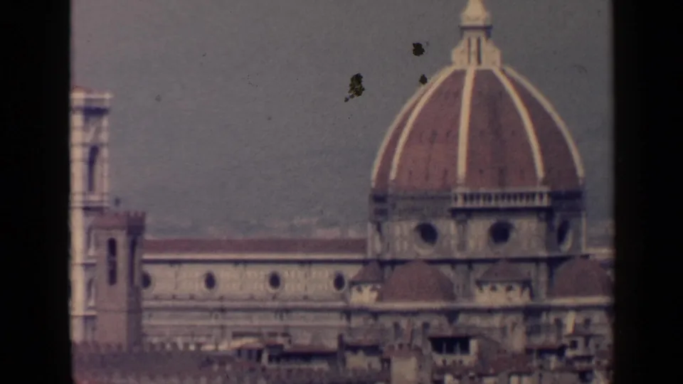 1960s 8mm view of Florence Cathedral dome and bell tower rising over terracotta rooftops.