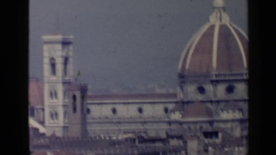 Florence Cathedral dome and bell tower appear through soft-focus 8mm color footage, with city rooftops in the foreground.