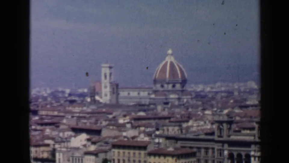 1960 8mm travel view of Florence's skyline, with the Duomo dome and bell tower rising above dense rooftops.