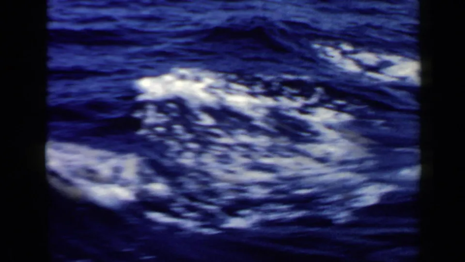 1960 8mm Rome-area sea footage showing foamy wake-like water in the foreground and a distant boat near the horizon.